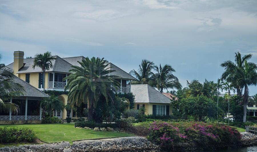 A single-story stucco house with a tile roof and palms in Fort Lauderdale